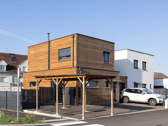 Maison individuelle avec bardage bois et carport.