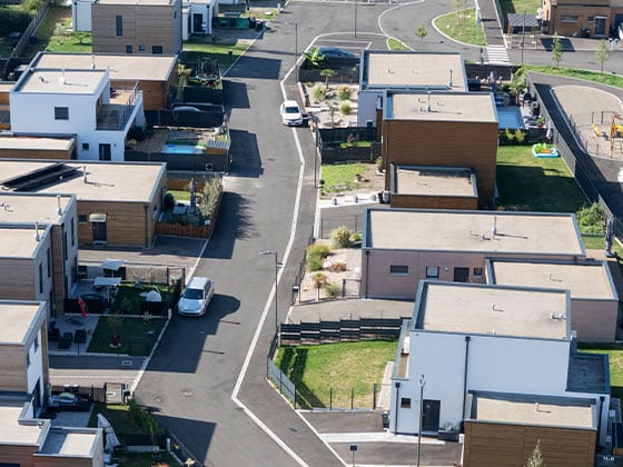 Vue aérienne d'une rue bordée de maisons à ossature bois.