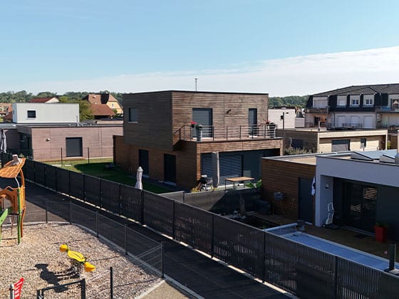 Une maison individuelle avec bardage bois foncé.